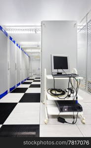 A Management Console in a Computer Datacenter. There are no people viewable. Vertically framed shot.