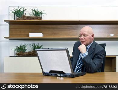 A manager thinking hard behind a laptop