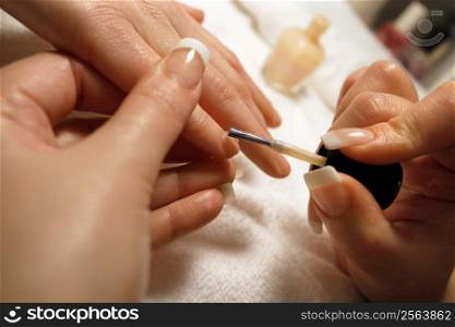 A manicurist applying nail polish during a manicure.