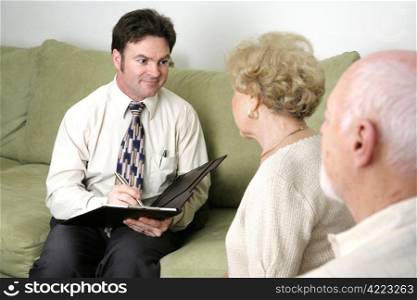 A marriage counselor or salesman listening to an elderly couple. Could also be a salesman.