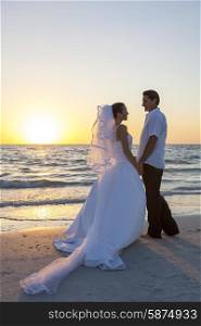 A married couple, bride and groom, together sunset sunrise on a beautiful tropical beach