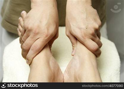 A masseuse massaging the feet of a woman