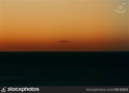 A massive horizon with an orange gradient and a single cloud with copy space and a relaxing scene minimalistic