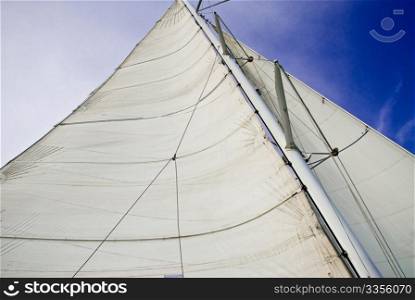 a mast with a sail of a catamaran