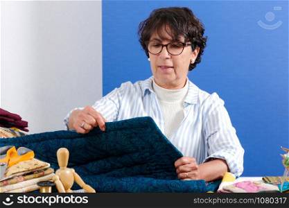 a mature brunette woman sewing patchwork