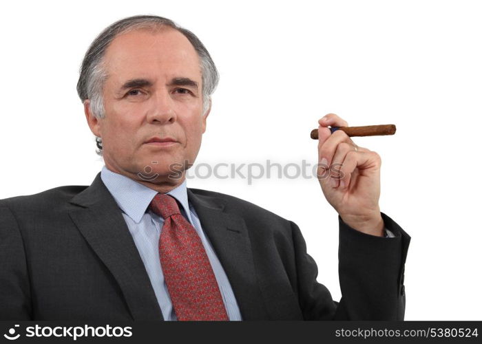 A mature businessman smoking a cigar.