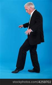 A mature businessman walking on a invisible line.