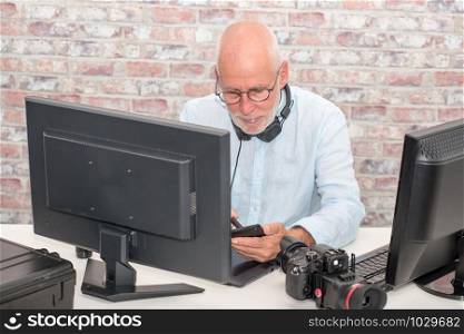 a mature businessman with glasses using computer