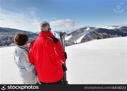 a mature couple in front of a beautiful snowy landscape