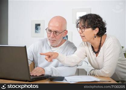 a mature couple using laptop at home