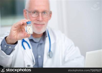a mature doctor with pill in hospital
