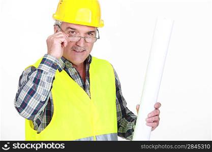 A mature foreman holding plans.