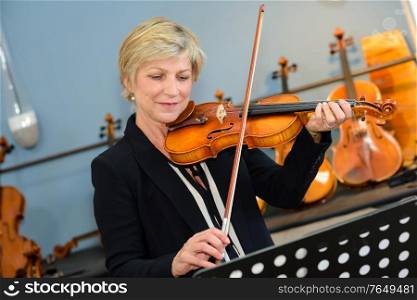 a mature lady practicing violin