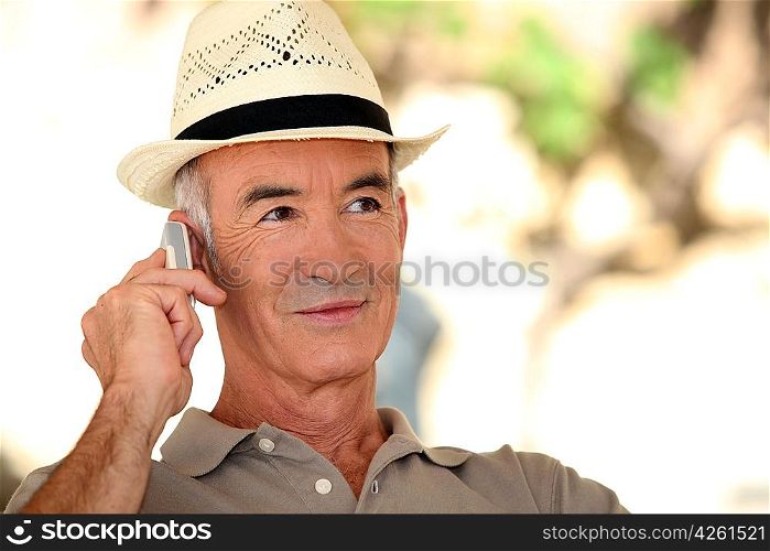 A mature man on the phone during a nice summer day.