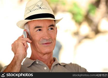 A mature man on the phone during a nice summer day.