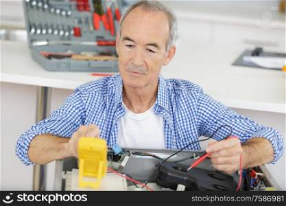 a mature man repairing a machine