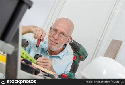 a mature man using screwdriver at home