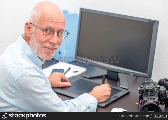 a mature man working on his graphics tablet