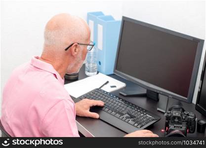 a mature man working with computer at office