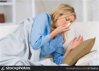 a mature sick woman sneezing