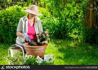 A mature woman planting flowers, sunny day