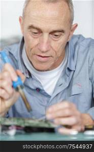 a mature worker soldering pc parts