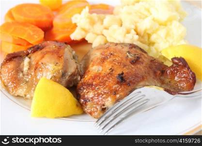 A meal of chicken thighs, marinaded in lemon juice and herbs and then roasted, served with mashed boiled potatoes and boiled carrots