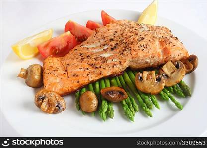 A meal of pan-fried salmon steak with steamed asparagus, fried mushrooms and fresh tomatoes
