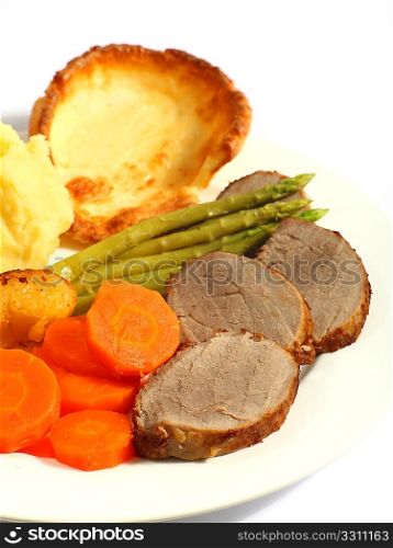 A meal of roast beef with carrots, mashed potatoes, asparagus and Yorkshire pudding.
