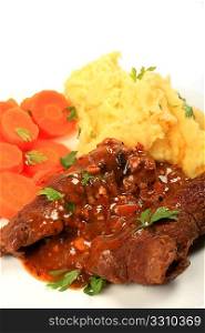 A meal of traditional British stuffed &acute;beef olive&acute; escalopes served with mashed potatoes and boiled carrots, vertical