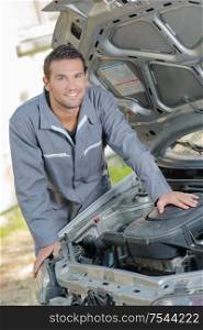 a mechanic is posing under hood