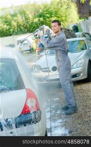 a mechanic power washing car
