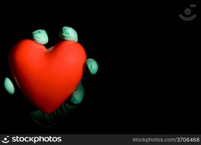 A medical professional holding a red heart.