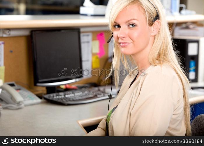 A medical receptionist at a desk with a phone headset