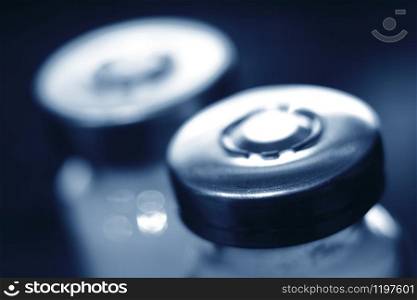 A medical syringe with a droplet of medicine in the needle. Medicine concept in blur.