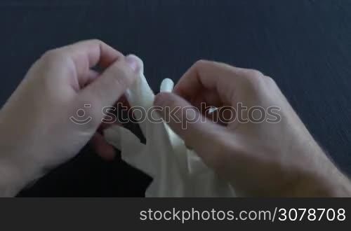 A medium shot of putting on surgical white gloves
