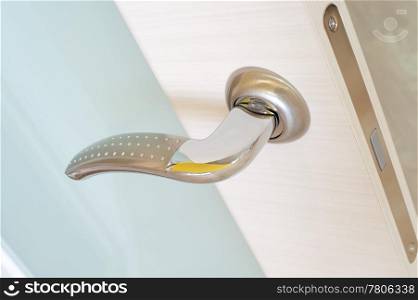 a metal handle on a beige door