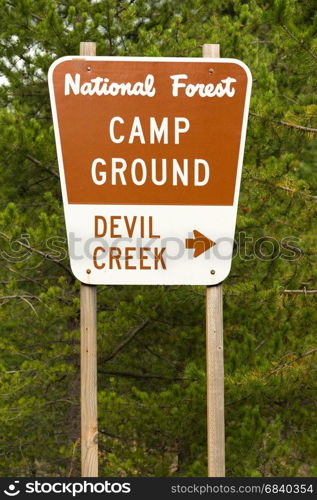 A metal sign along the highway points the way to Devil Creek Campground