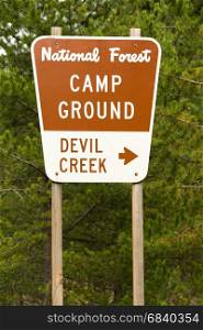 A metal sign along the highway points the way to Devil Creek Campground