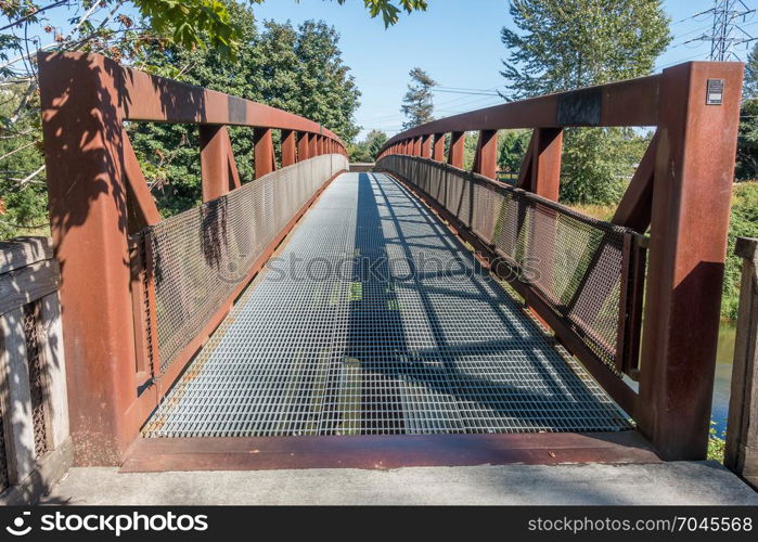 A metal walking bridge spans the Green River in Washington State.