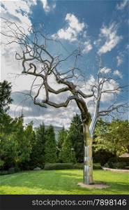 A metallic sculpture of a leafless tree with intricate branch structures