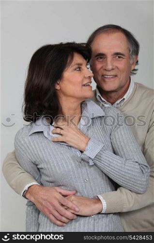 A middle age couple hugging.