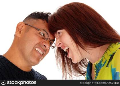 A middle age couple in a closeup with there head&rsquo;s together fighting andscreaming at each other, isolated for white background.