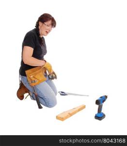 A middle age woman kneeling on the floor and working with some tools,isolated for white background.
