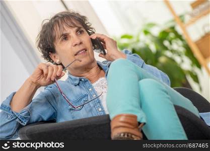 a middle age woman with glasses using and talking phone