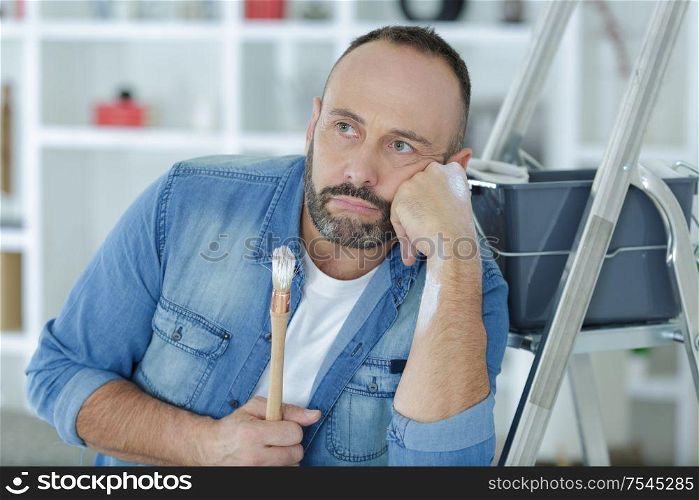 a middle aged man bored man after painting