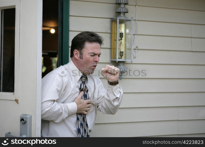 A middle aged man leaving a building and having a coughing fit.