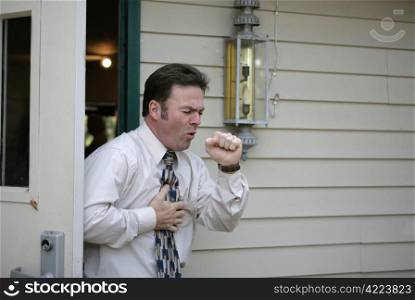 A middle aged man leaving a building and having a coughing fit.