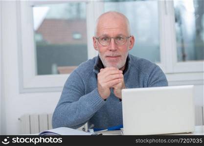 a middle-aged man using laptop in his office