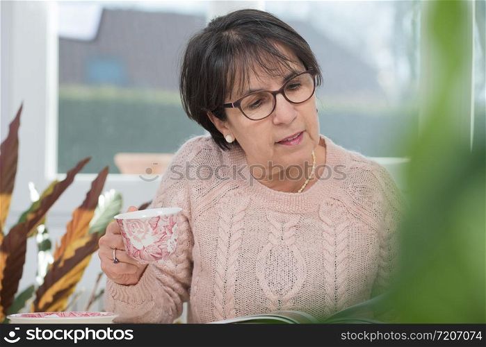 a middle-aged woman drinks a cup of coffee